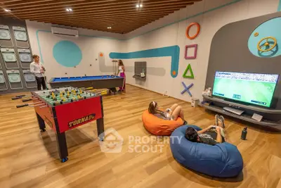 Modern game room with foosball, pool table, and gaming area for ultimate entertainment.