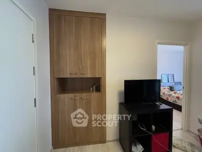Cozy bedroom with built-in wooden wardrobe and TV stand, perfect for modern living.