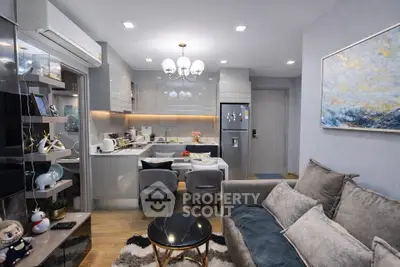 Modern living room with open kitchen, stylish decor, and cozy seating area in a contemporary apartment.