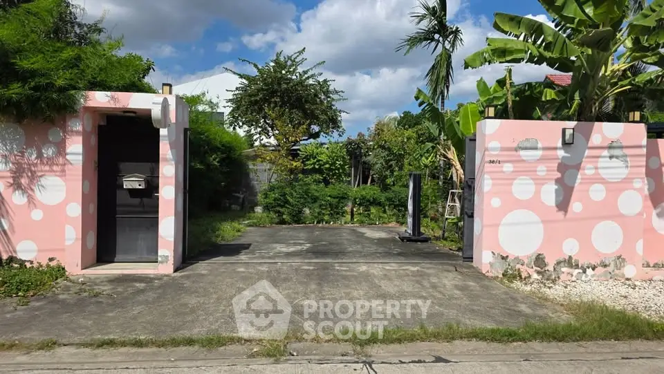 Charming pink entrance with polka dots and lush greenery, perfect for a unique property.