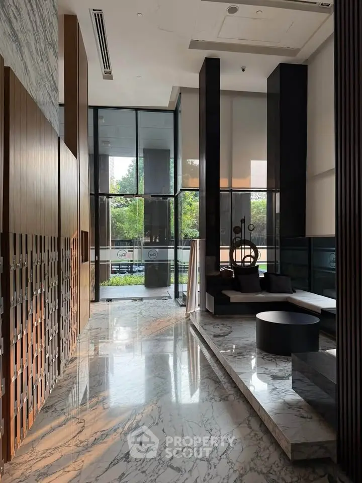 Luxurious modern lobby with marble floors and stylish seating area, featuring floor-to-ceiling windows and elegant decor.