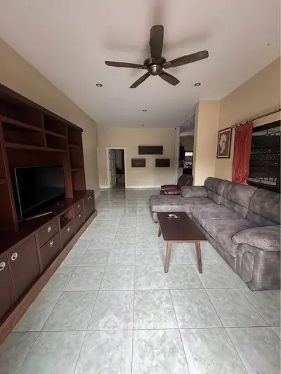 Spacious living room with modern ceiling fan and comfortable seating, perfect for relaxation and entertainment.