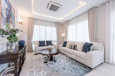 Elegant living room with modern decor, featuring plush sofas, stylish coffee table, and ambient lighting.