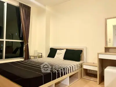 Modern bedroom with stylish decor and large window for natural light.