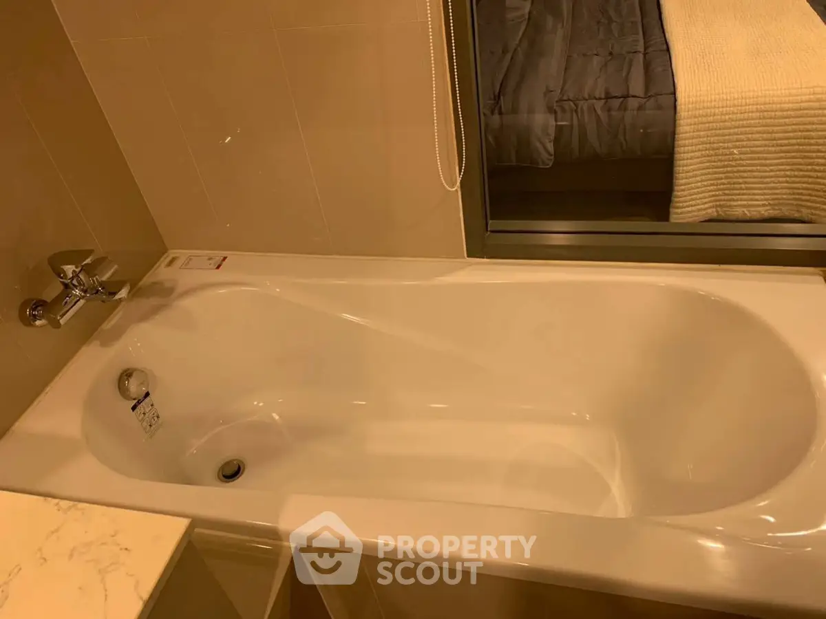 Luxurious bathroom with modern bathtub and cozy bedroom view, perfect for relaxation and comfort.