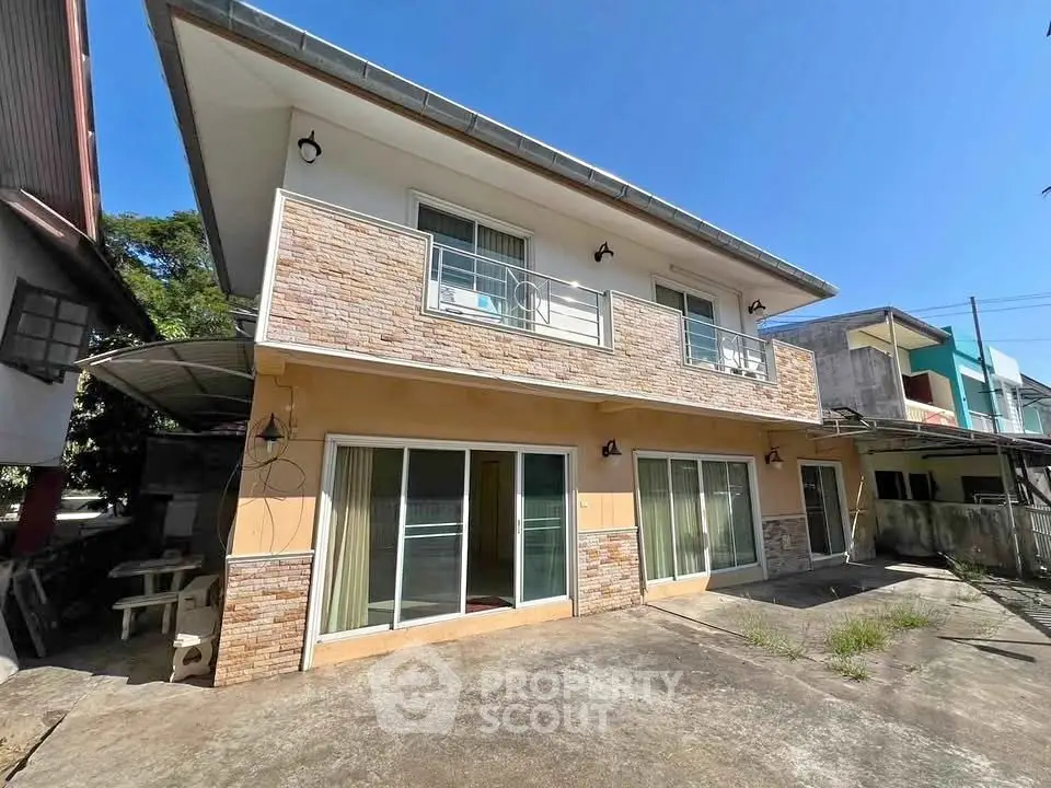 Charming two-story house with balcony and spacious driveway in sunny neighborhood.
