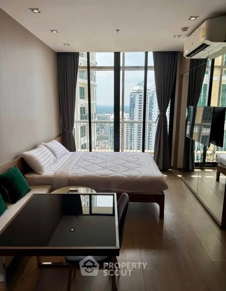 Modern bedroom with city view, featuring large windows, cozy bed, and stylish decor in a high-rise apartment.