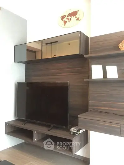 Modern living room with sleek TV unit and stylish wooden shelves.