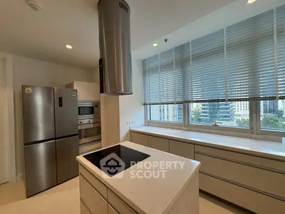 Modern kitchen with sleek appliances and large windows offering city views.