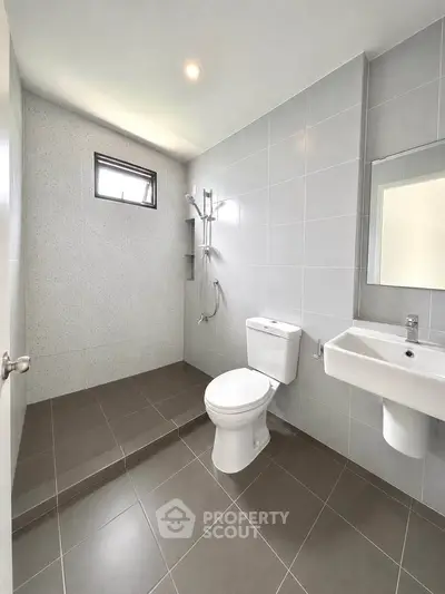 Modern bathroom with sleek gray tiles and walk-in shower design