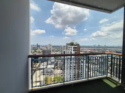 Stunning high-rise balcony with panoramic city views and clear blue skies.