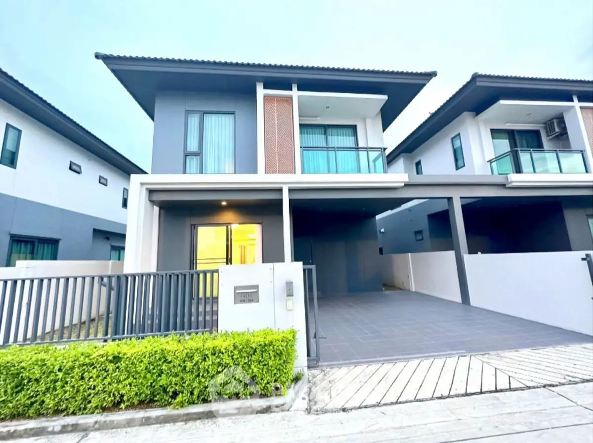 Modern two-story house with sleek design and spacious driveway in a serene neighborhood.