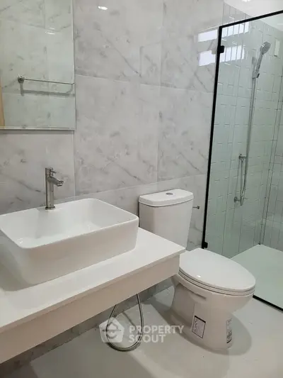 Modern bathroom with sleek fixtures and glass shower enclosure