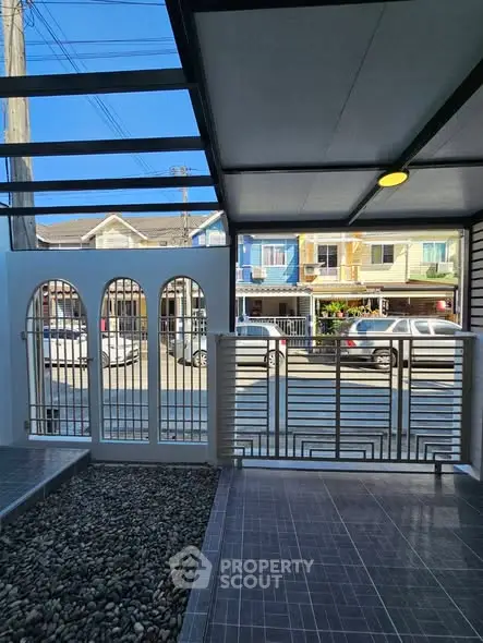 Modern covered patio with stylish railing and street view