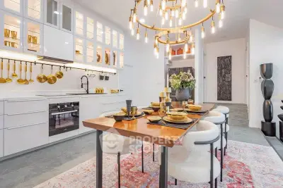 Luxurious modern kitchen with elegant dining area and stylish lighting fixtures.