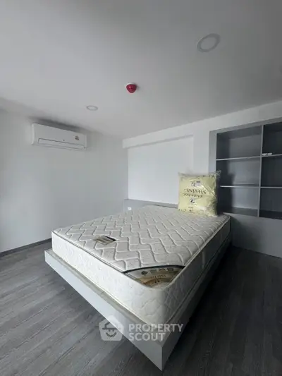 Modern minimalist bedroom with air conditioning and built-in shelving