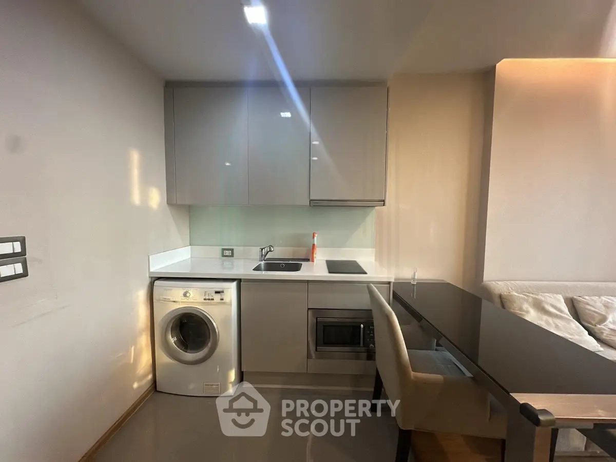 Modern compact kitchen with washing machine and sleek cabinetry