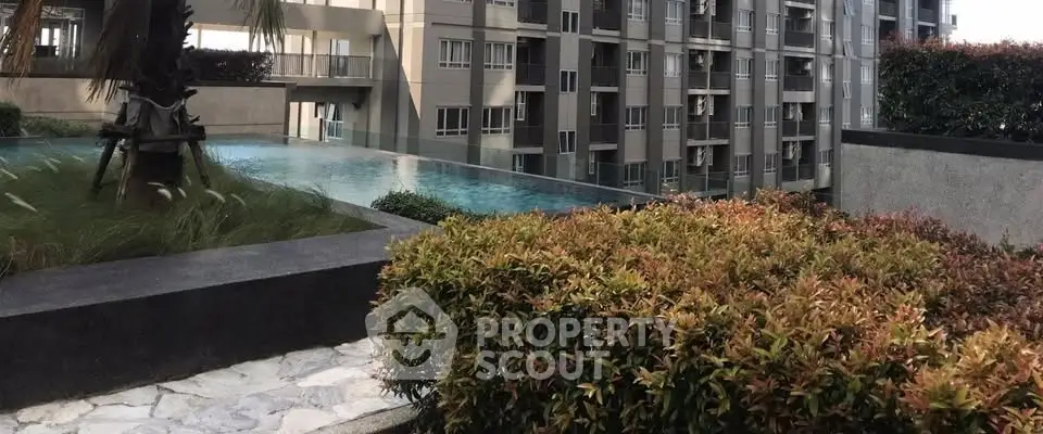 Luxurious apartment building with serene pool and lush landscaping