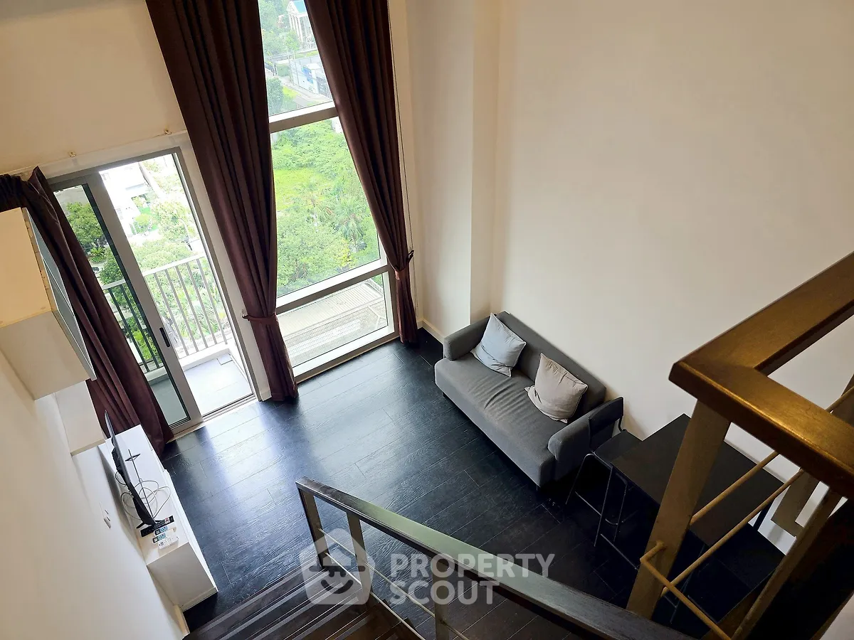Spacious loft with large windows and modern decor, offering a stunning view.
