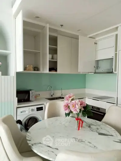 Modern kitchen with marble table, washing machine, and open cabinets