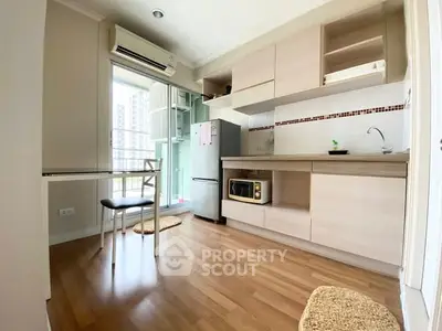 Modern kitchen with open layout and wooden flooring in a bright apartment.