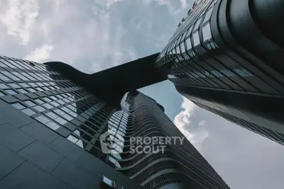 Stunning modern skyscraper with unique architectural design and sky bridge, perfect for urban living.