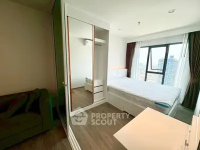 Modern bedroom with city view, featuring sleek furniture and large windows for natural light.