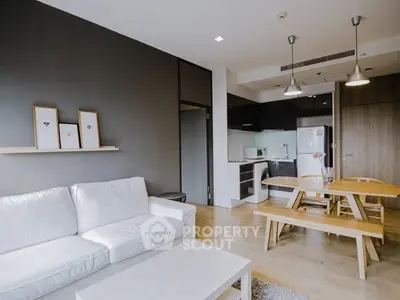 Modern open-plan living room and kitchen with sleek design and cozy ambiance.