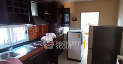 Charming kitchen with dark wood cabinets and modern appliances