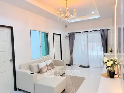 Elegant living room with chandelier and modern decor, featuring a cozy sofa and stylish curtains.
