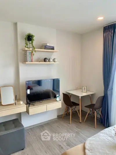 Modern living room with stylish decor, wall-mounted TV, and cozy dining area.