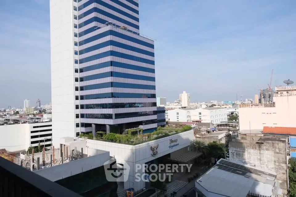 Stunning cityscape view with modern high-rise building and clear blue sky.
