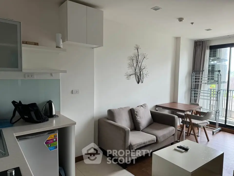 Modern living room with cozy sofa and dining area, featuring natural light and minimalist decor.