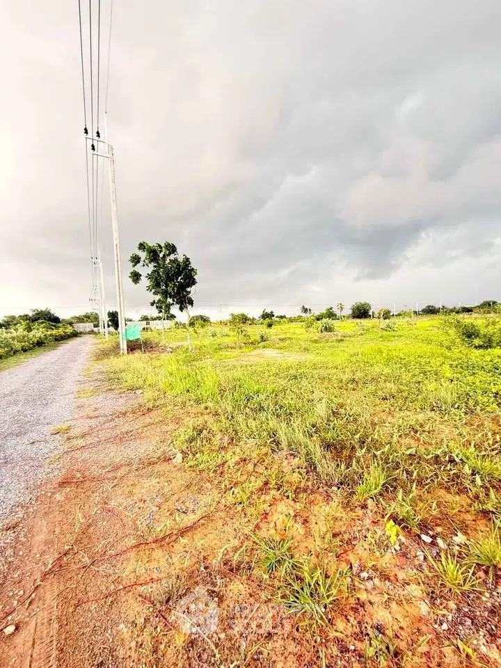 Expansive plot of land with lush greenery and clear skies, ideal for development opportunities.