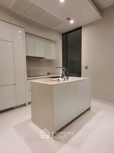 Sleek modern kitchen with island and minimalist design in luxury apartment