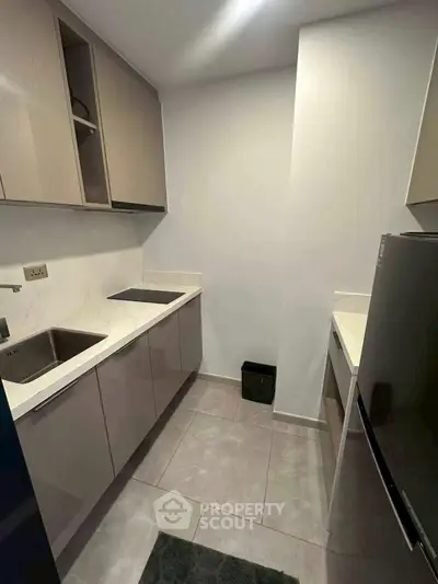 Modern compact kitchen with sleek cabinetry and integrated appliances.