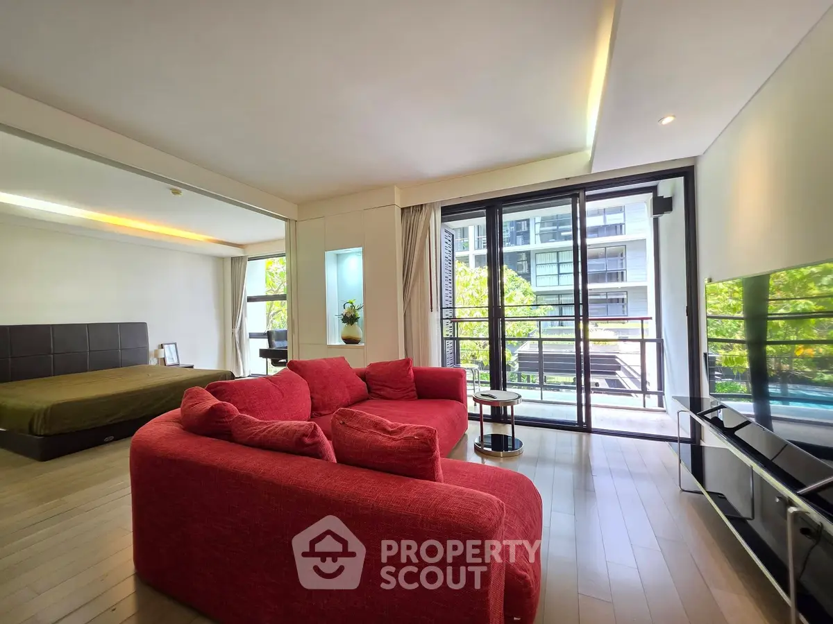 Spacious modern living room with red sofa and balcony view in luxury apartment