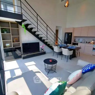 Modern loft-style living room with open kitchen and stylish staircase