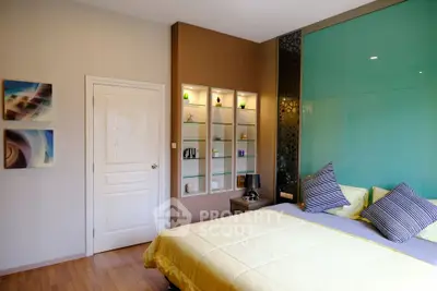Modern bedroom with stylish decor and built-in shelving, featuring a cozy bed and elegant design elements.