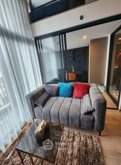 Modern living room with cozy sofa and floor-to-ceiling windows in a stylish apartment.
