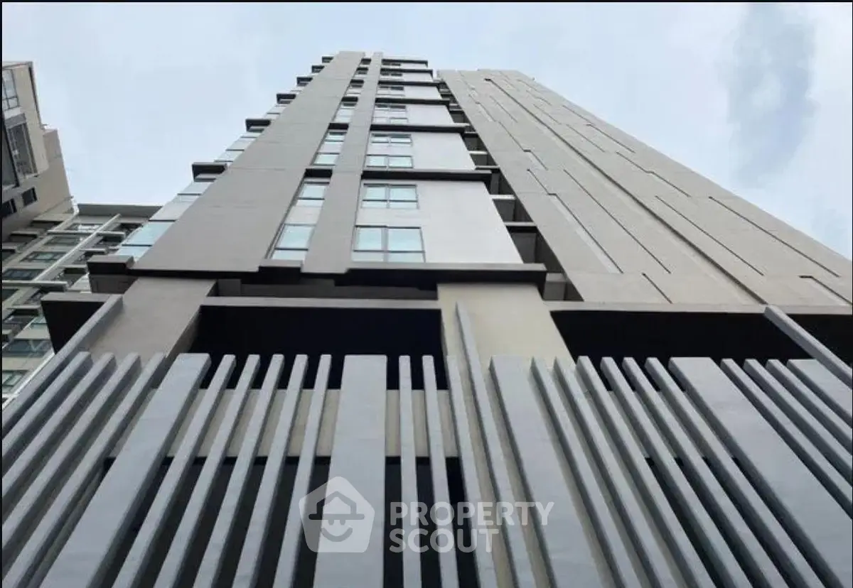 Modern high-rise building with sleek architectural design and large windows.