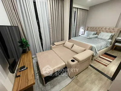 Modern studio apartment with cozy bed and stylish sofa bed in open layout.