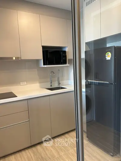 Modern kitchen with sleek cabinetry and stainless steel appliances in a contemporary apartment.