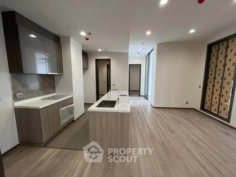 Modern open-layout kitchen with sleek cabinetry and island in a spacious apartment.