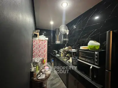 Compact kitchen with dark marble walls and modern appliances
