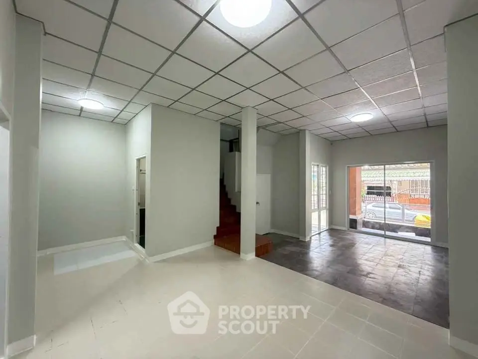 Spacious open-plan living area with modern tiled flooring and ample natural light.