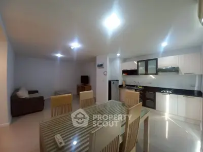 Spacious open-plan living and dining area with modern kitchen in a stylish apartment.