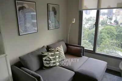 Modern living room with stylish gray sofa and city view window