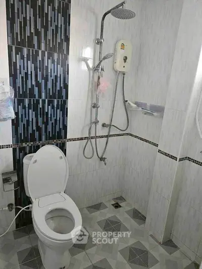 Modern bathroom with shower and toilet featuring stylish tile design.