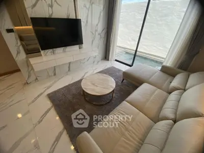 Luxurious living room with marble accents and modern furniture overlooking a serene pool view.